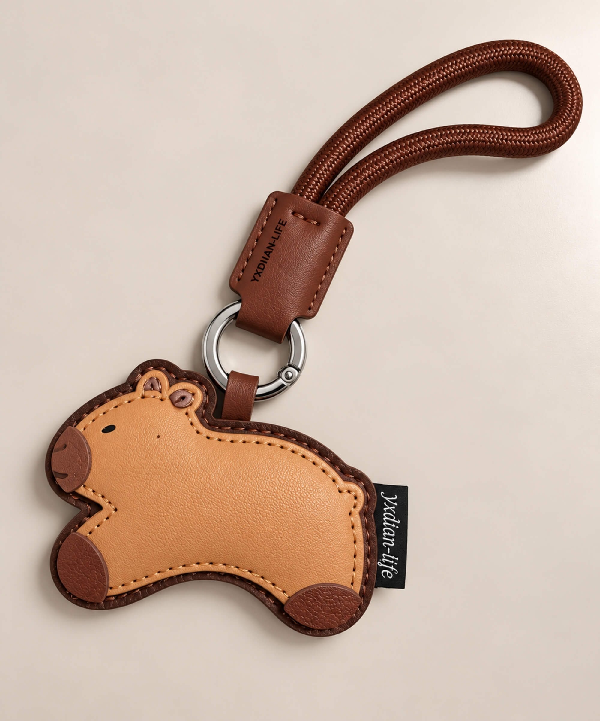 Classic Capybara PU leather bag charm keychain in warm brown tones with matching wrist loop
